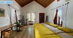 een slaapkamer met een groot bed met gele lakens bij Ninh Binh Eco Garden in Ninh Binh