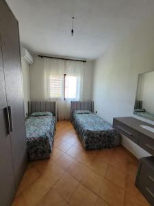 Zimmer mit 2 Betten und einem Waschbecken. in der Unterkunft Casa Shtoj I Vjeter, Shkoder 