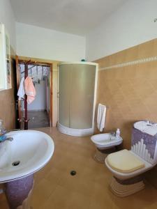 ein Badezimmer mit einer Badewanne, einem WC und einem Waschbecken in der Unterkunft Casa Shtoj I Vjeter, Shkoder 