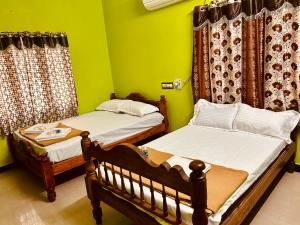 two beds in a room with green walls at DE Villa Breeze @ Beach side in Pondicherry