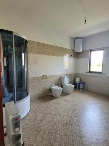 ein Badezimmer mit 2 WCs und einer großen Dusche in der Unterkunft Casa Shtoj I Vjeter, Shkoder 