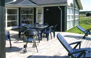 a patio with a table and chairs and a grill at Amazing Home In Jerup With 4 Bedrooms, Sauna And Wifi in Jerup