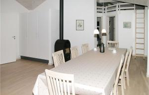a dining room with a white table and chairs at Amazing Home In Jerup With 4 Bedrooms, Sauna And Wifi in Jerup