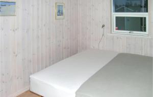 a white bed in a pink room with a window at Amazing Home In Jerup With 4 Bedrooms, Sauna And Wifi in Jerup