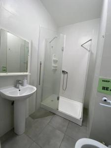 y baño blanco con lavabo y ducha. en Green Kitchen Apartments en Mukacheve