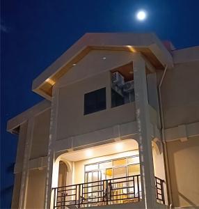 a night view of a building with the moon in the sky at Kanalung Yurakucho House in Taimali