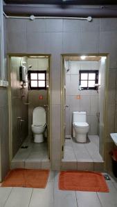 a bathroom with two toilets and a door open at BRICKS Backpackers Sleepbox in Tanah Rata