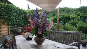 a vase of flowers sitting on a table in a garden at jolie maison in Épinal