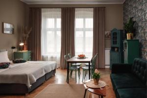 a bedroom with a bed and a table and a couch at Apartamenty Piotrkowska 82 by Good Time in Łódź