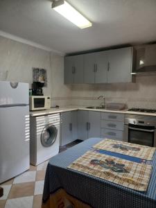 uma cozinha com armários brancos, um lavatório e uma máquina de lavar louça em Casa Familiar Boa Fé em Elvas