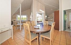 Il comprend une cuisine et une salle à manger avec une table et des chaises en bois. dans l'établissement Cozy Home In Blvand With Kitchen, à Blåvand