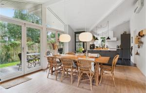 a kitchen and dining room with a wooden table and chairs at 3 Bedroom Nice Home In Sams in Sælvig
