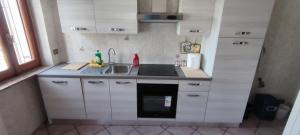 eine kleine Küche mit weißen Schränken und einem Waschbecken in der Unterkunft Alloggio turistico Matteo Simoncini in Montefiascone