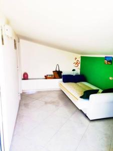 Una habitación con una pared verde y una cama en Colorful House Costa Trabocchi en San Vito Chietino