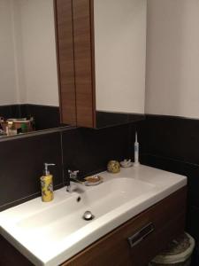 een badkamer met een witte wastafel en een spiegel bij CASA degli OLIVI GARDA LAKE in Riva del Garda