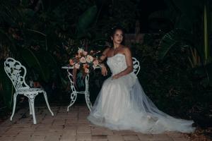 Una donna con un vestito da sposa seduta su una sedia con un bouquet di Manatee Palms a Bradenton