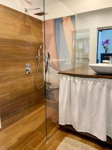 bagno con doccia in vetro e lavandino di Apartment Storczykowa Airport a Danzica