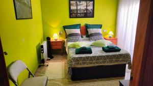 niewielka sypialnia z łóżkiem z zielonymi ścianami w obiekcie Apartamento Galeon XXI w mieście Torrevieja
