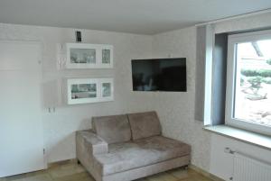 sala de estar con sofá y TV en Ferienwohnung Lotti en Burrweiler