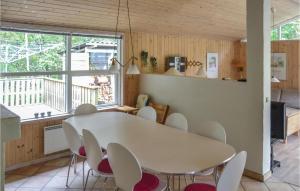a dining room with a white table and chairs at Gorgeous Home In lbk With Sauna in Ålbæk