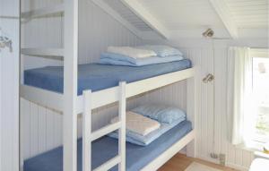 two bunk beds in a white room with towels at 3 Bedroom Awesome Home In Strandby in Strandby