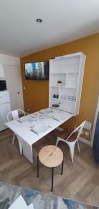 una sala da pranzo bianca con tavolo e sedie bianchi di Appart Cosy Place Saint-Jean a Niort