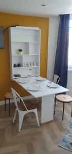 - une table et des chaises blanches dans la chambre dans l'établissement Appart Cosy Place Saint-Jean, à Niort