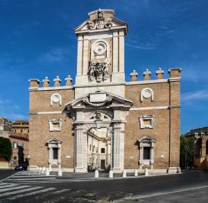 duży ceglany budynek z wieżą zegarową w obiekcie Baltik Guesthouse w Rzymie