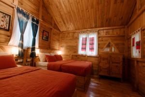 a bedroom with two beds in a log cabin at The November - Moc Chau in Mộc Châu