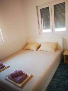 ein weißes Bett mit zwei Handtüchern darüber in der Unterkunft Apartman Dream House in Mostar