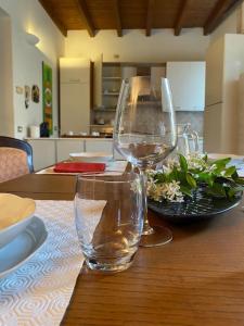 una mesa con dos copas de vino y un tazón de flores en La Casa nel Borgo, en Angera
