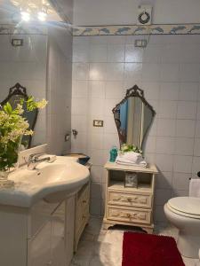 a bathroom with a sink and a toilet and a mirror at La Casa nel Borgo in Angera