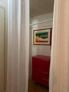 una habitación con una cómoda roja y una foto en La Casa nel Borgo, en Angera