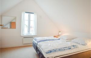 - une chambre blanche avec un lit et une fenêtre dans l'établissement Blvandslyst, à Blåvand