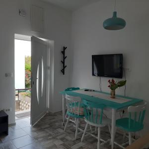 a dining room with a blue table and chairs at Apartman Pelargo in Poljana