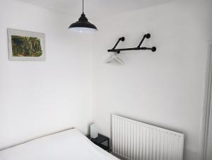 een witte slaapkamer met een bed en een lamp bij Maison Blanc in Nottingham