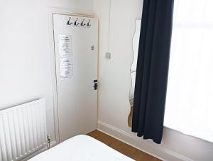 een slaapkamer met een witte deur en een raam bij Maison Blanc in Nottingham