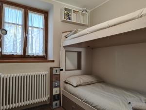 1 Schlafzimmer mit 2 Etagenbetten und einem Fenster in der Unterkunft Suite a Folgaria in Folgaria