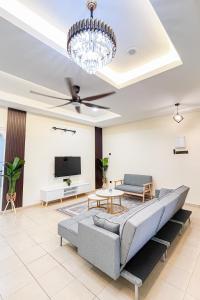 - un salon avec un canapé et une télévision dans l'établissement Homestay Desa (Bukit Baru, Melaka), à Malacca