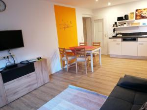 a living room with a table and a kitchen at Ferienwohnung Dorn in Argenbühl