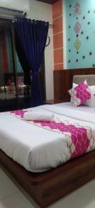a bedroom with two beds and a blue curtain at HOTEL OM SAI in Vovale