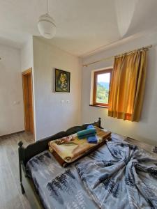 een slaapkamer met een bed met een deken erop bij Guest House Korabi in Ceren
