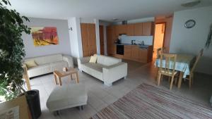 ein Wohnzimmer mit 2 weißen Sofas und einer Küche in der Unterkunft Gästehaus Lutz in Mellau