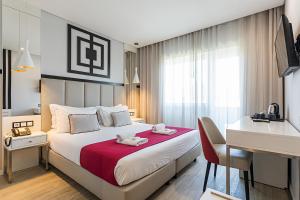 Habitación de hotel con cama, escritorio y escritorio. en Hotel Canada en Lisboa