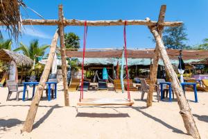 a swing set on the beach with chairs and tables at Feel the Waves in Arugam Bay