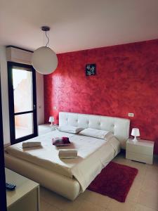 庫亞圖丘的住宿－Appartamento Carino，一间卧室设有一张红色墙壁的大床