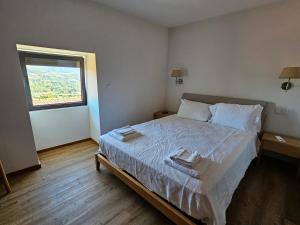 ein Schlafzimmer mit einem Bett mit zwei Handtüchern darauf in der Unterkunft Quinta de Casal do Bairro Casa Grande in Guimarães