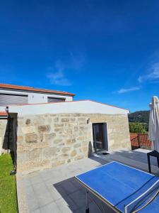 una mesa de ping pong frente a un edificio de piedra en Quinta de Casal do Bairro Casa Grande en Guimarães