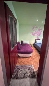 ブルガスにあるСладкият кът на Радостの紫色のソファとドア付きのリビングルーム
