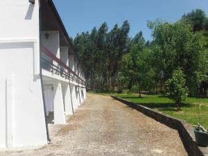 uma estrada de terra ao lado de um edifício branco em Hotel Alameda em Albergaria-a-Velha